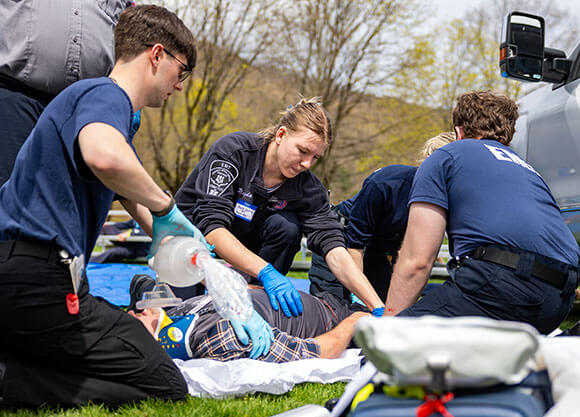 Students and area EMTs engage in a simulation.